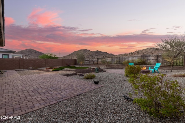 exterior space featuring a patio, a mountain view, and a fire pit