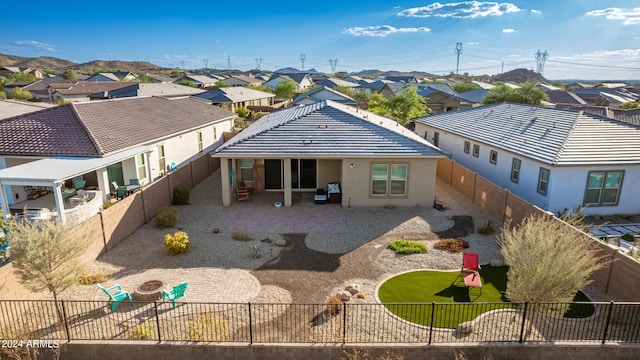 rear view of property featuring an outdoor fire pit and a patio area