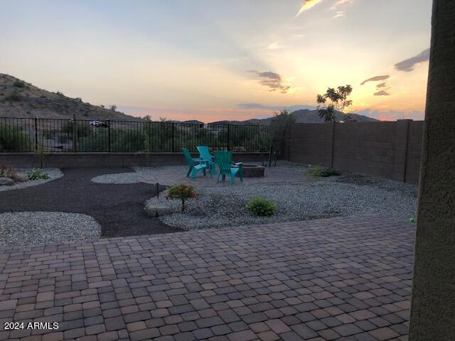 patio terrace at dusk with a mountain view and an outdoor fire pit