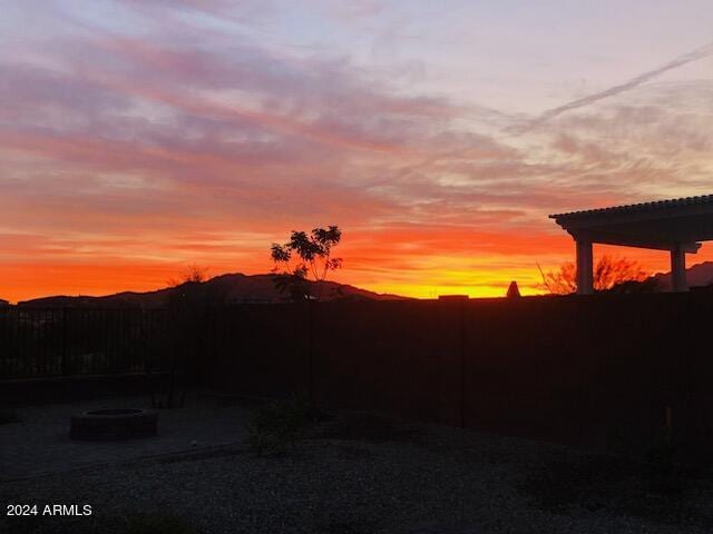 yard at dusk featuring a fire pit and a pergola