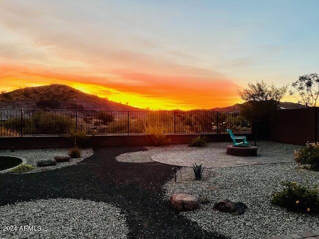 yard at dusk featuring a mountain view and a patio area