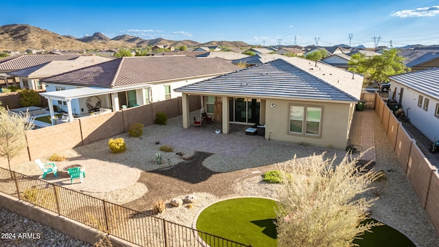 rear view of house with a mountain view and a patio area