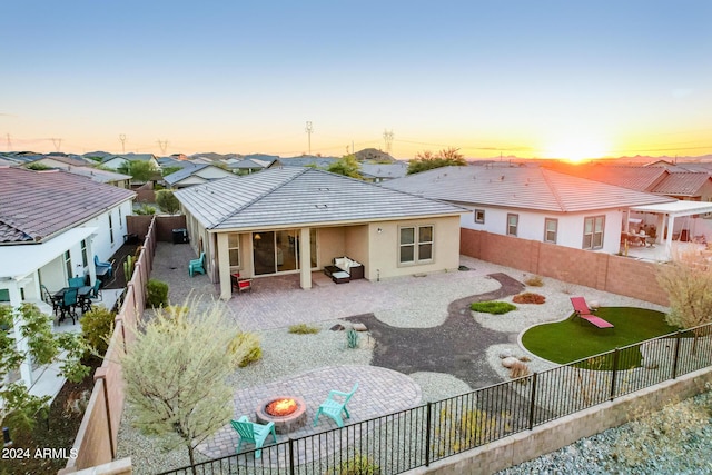 back house at dusk with a patio and an outdoor fire pit