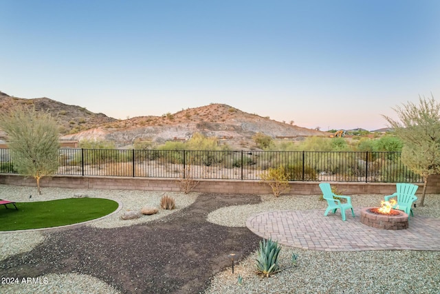 yard at dusk with a patio, a mountain view, and an outdoor fire pit