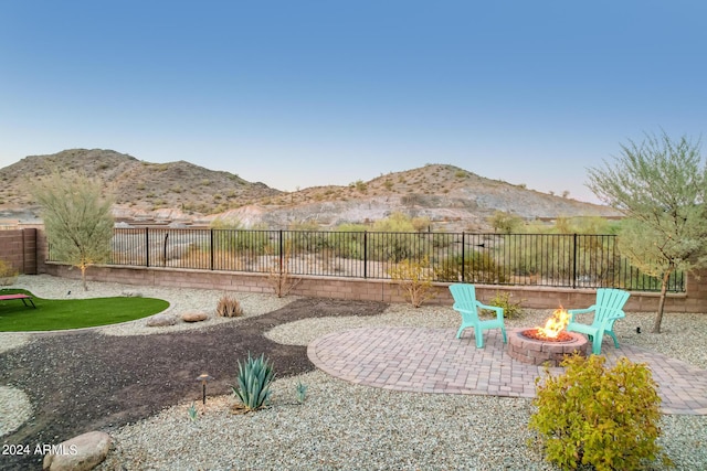 view of patio with an outdoor fire pit and a mountain view