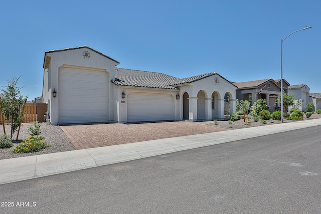17819 W Georgia Ave, Litchfield Park, AZ 85340 - mediterranean / spanish home featuring an attached garage, stucco siding, driveway, and a tile roof
