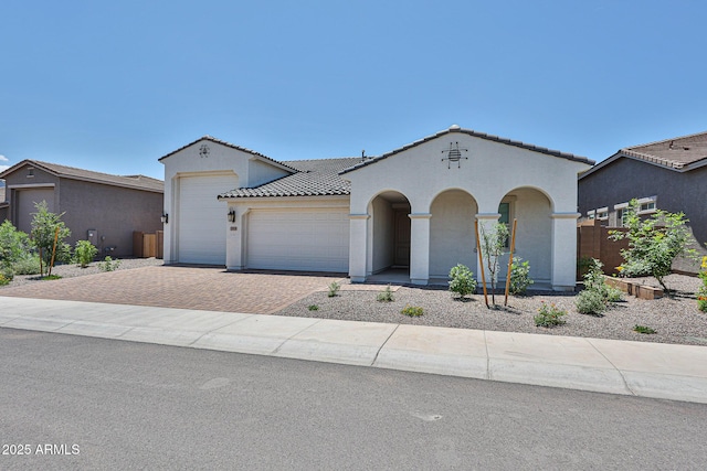 17819 W Georgia Ave, Litchfield Park, AZ 85340 - mediterranean / spanish home featuring decorative driveway, stucco siding, a garage, and a tiled roof