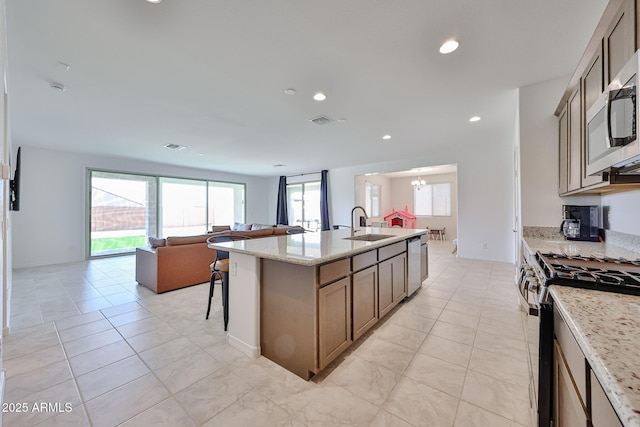 17819 W Georgia Ave, Litchfield Park, AZ 85340 - kitchen with stainless steel appliances, open floor plan, recessed lighting, a kitchen bar, and an island with sink