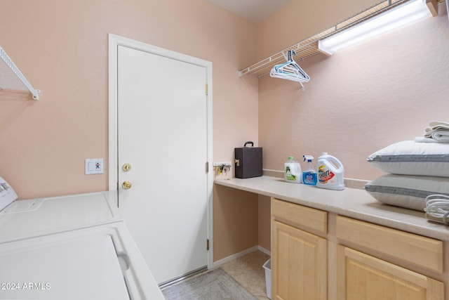 washroom with cabinets, separate washer and dryer, and light tile patterned flooring