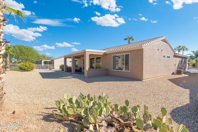 rear view of property featuring central air condition unit and a patio