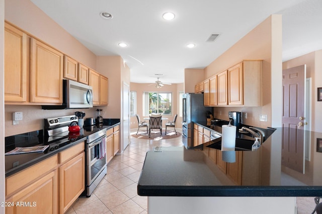 kitchen featuring sink, light brown cabinetry, light tile patterned flooring, and appliances with stainless steel finishes