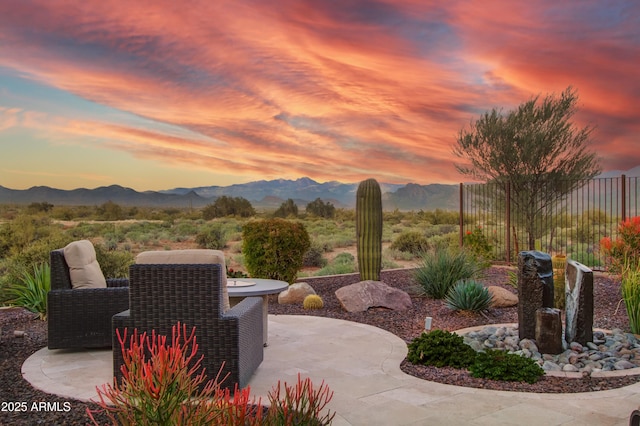 patio terrace at dusk featuring a mountain view