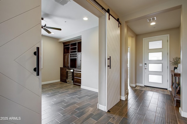 entrance foyer featuring ceiling fan and a barn door