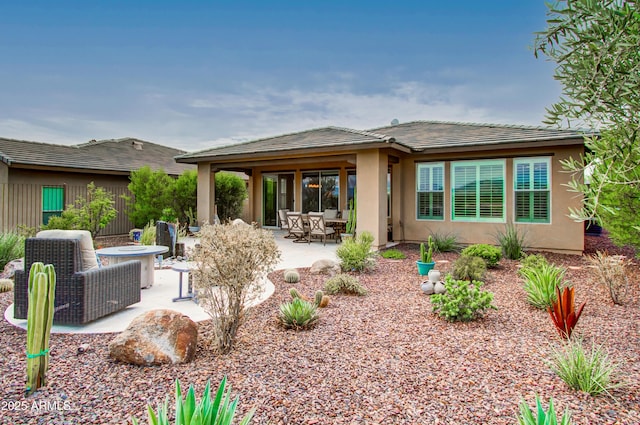 rear view of house with a patio area and an outdoor living space