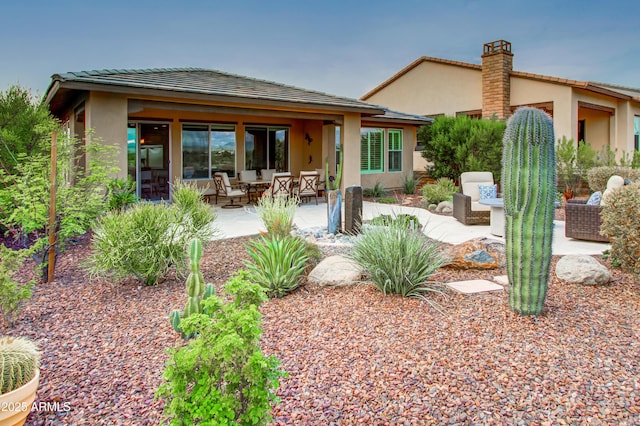 rear view of property with an outdoor living space and a patio area