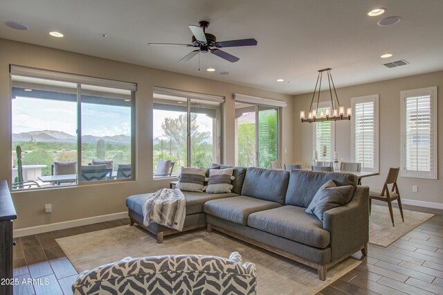 living room featuring a mountain view and ceiling fan with notable chandelier