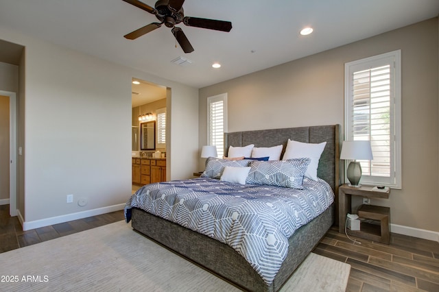 bedroom featuring multiple windows, ensuite bathroom, ceiling fan, and dark hardwood / wood-style floors