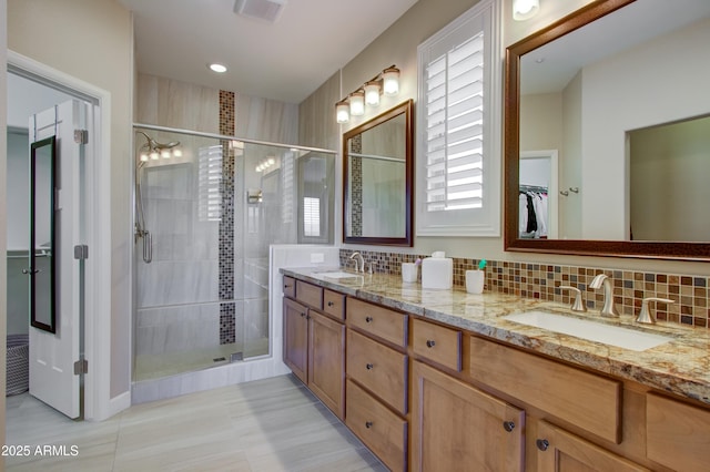 bathroom featuring decorative backsplash, vanity, and walk in shower