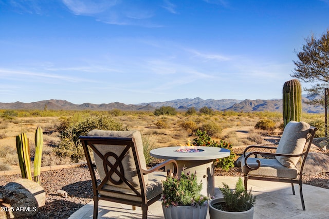 view of patio with a fire pit and a mountain view