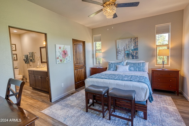 bedroom featuring connected bathroom, light hardwood / wood-style floors, and ceiling fan