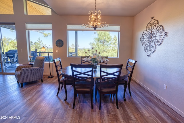 dining area with a wealth of natural light, hardwood / wood-style floors, and an inviting chandelier