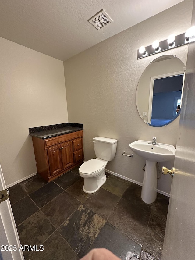 bathroom with sink, a textured ceiling, and toilet