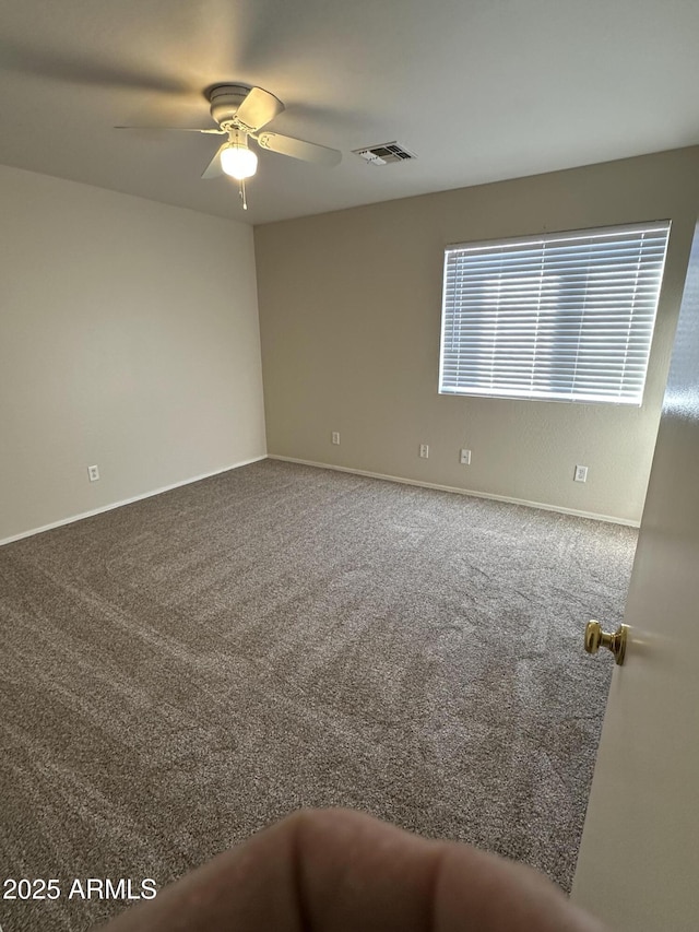 carpeted spare room with ceiling fan