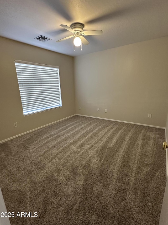 unfurnished room with ceiling fan and carpet