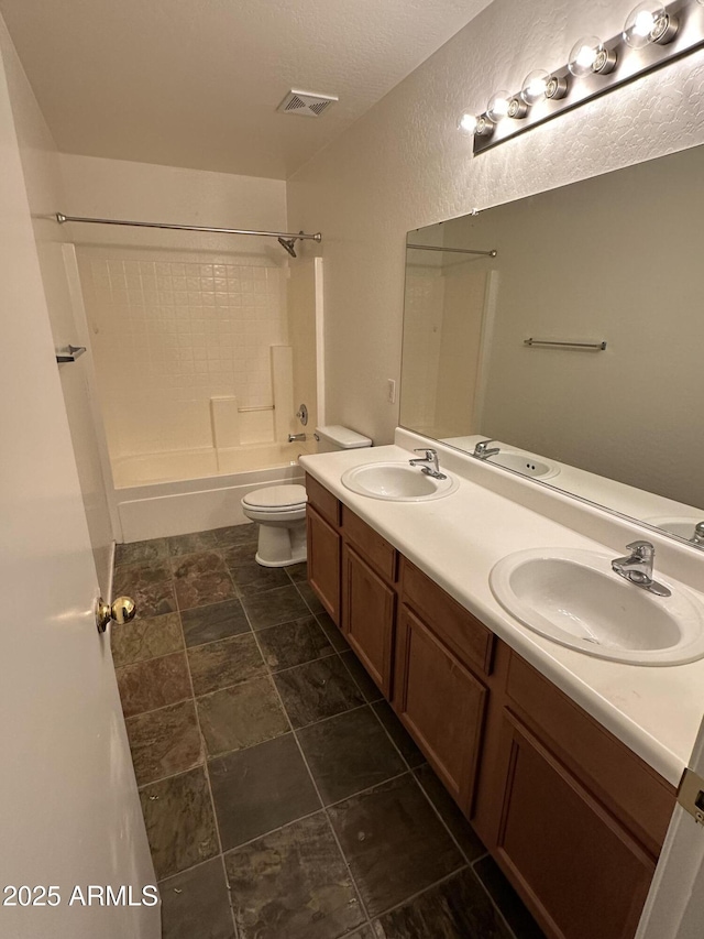 full bathroom featuring toilet, a textured ceiling, shower / bathtub combination, and vanity