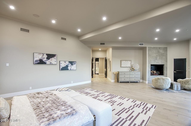 bedroom featuring a fireplace and light wood-type flooring