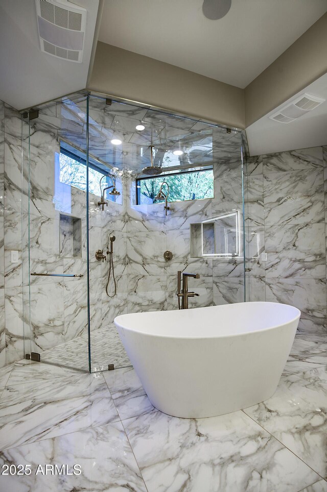 bathroom featuring a healthy amount of sunlight and shower with separate bathtub