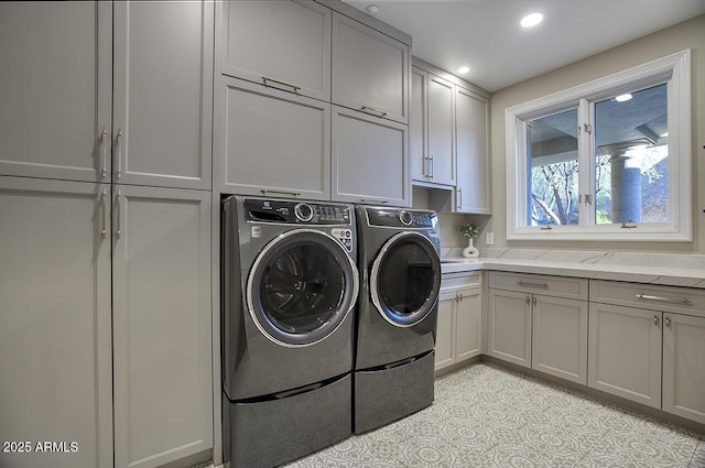 clothes washing area featuring independent washer and dryer and cabinets