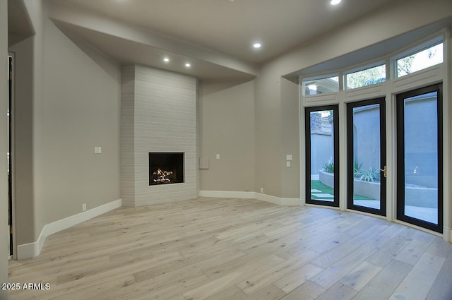 unfurnished living room featuring light hardwood / wood-style flooring and a fireplace