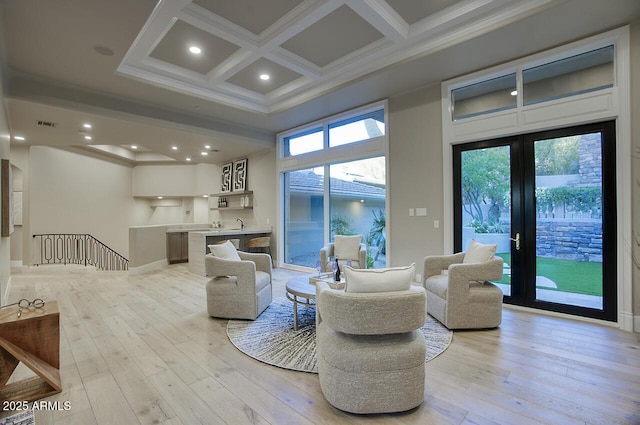 living room featuring crown molding, light hardwood / wood-style flooring, coffered ceiling, french doors, and beamed ceiling