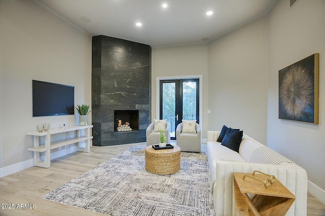 living room featuring a high end fireplace and light hardwood / wood-style flooring