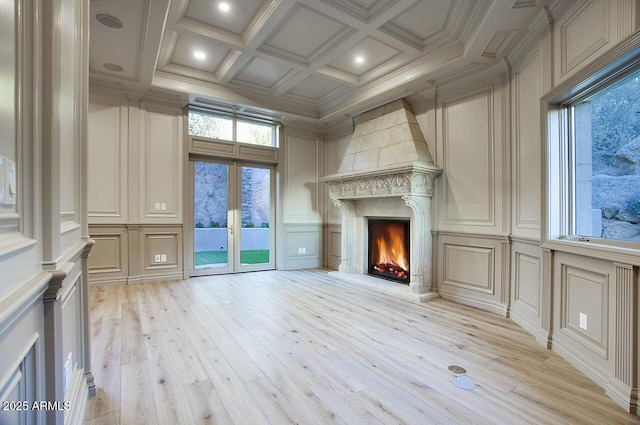 unfurnished living room featuring coffered ceiling, crown molding, beamed ceiling, and light wood-type flooring