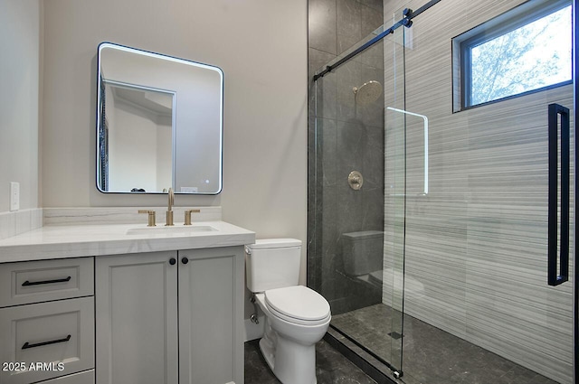 bathroom with toilet, vanity, and a shower with shower door