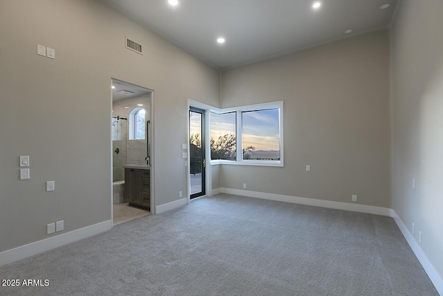 unfurnished bedroom featuring light colored carpet, connected bathroom, and sink