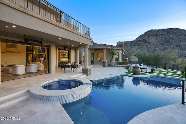 view of pool with an in ground hot tub, an outdoor hangout area, a mountain view, and a patio