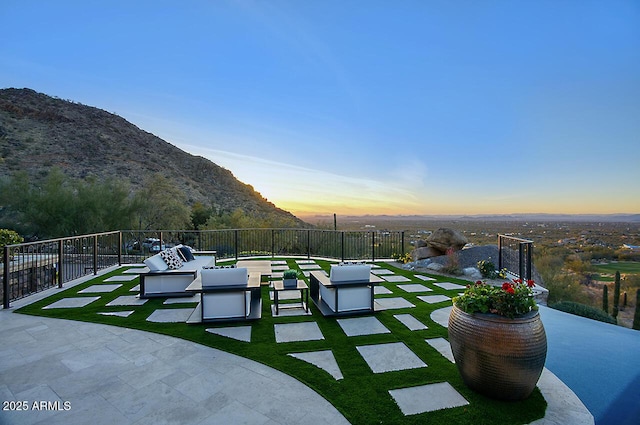 patio terrace at dusk featuring an outdoor living space and a mountain view