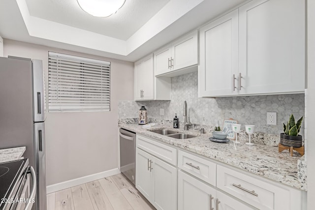3119 W Cochise Dr Unit 111, Phoenix, AZ 85051 - kitchen featuring a sink, appliances with stainless steel finishes, light wood finished floors, a raised ceiling, and decorative backsplash