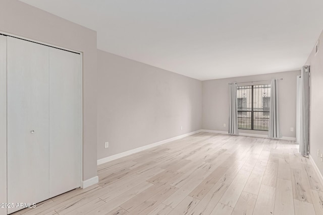 3119 W Cochise Dr Unit 111, Phoenix, AZ 85051 - unfurnished bedroom with light wood-type flooring, baseboards, and a closet