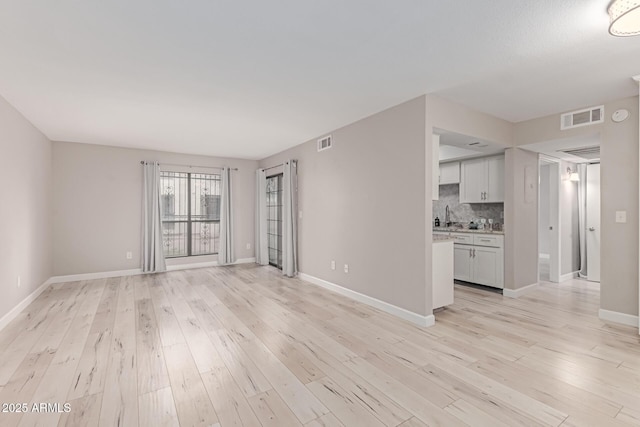 3119 W Cochise Dr Unit 111, Phoenix, AZ 85051 - unfurnished living room with light wood-style floors and baseboards