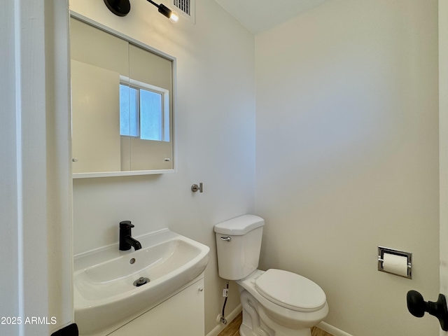 bathroom with vanity, toilet, baseboards, and visible vents