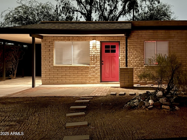 view of exterior entry featuring brick siding