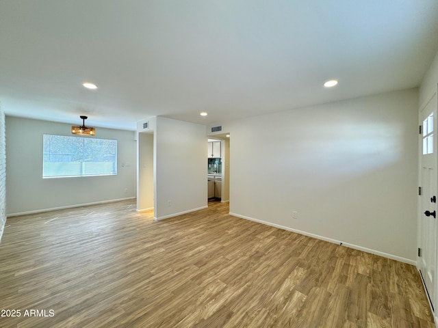 empty room with visible vents, recessed lighting, light wood-type flooring, and baseboards