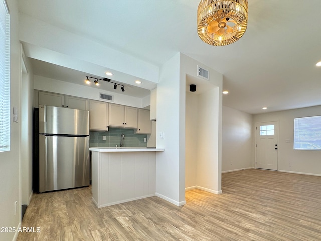 kitchen with light countertops, gray cabinets, visible vents, and freestanding refrigerator