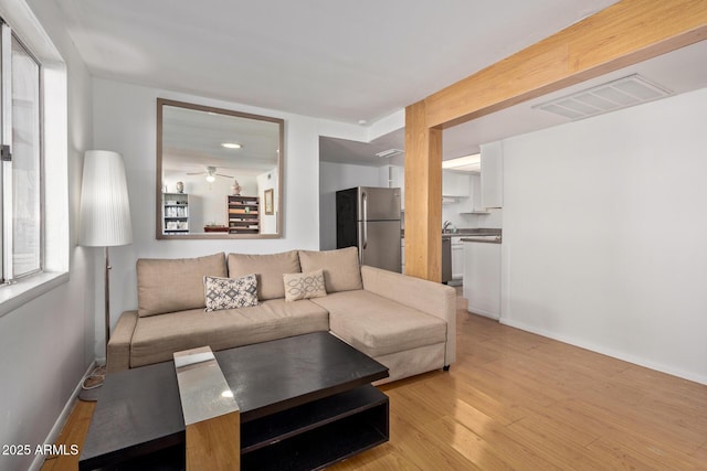 living room with ceiling fan and light hardwood / wood-style flooring