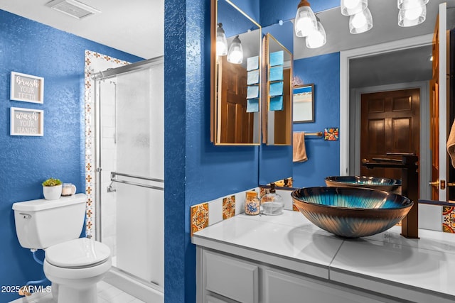 full bath featuring visible vents, a textured wall, toilet, a stall shower, and vanity