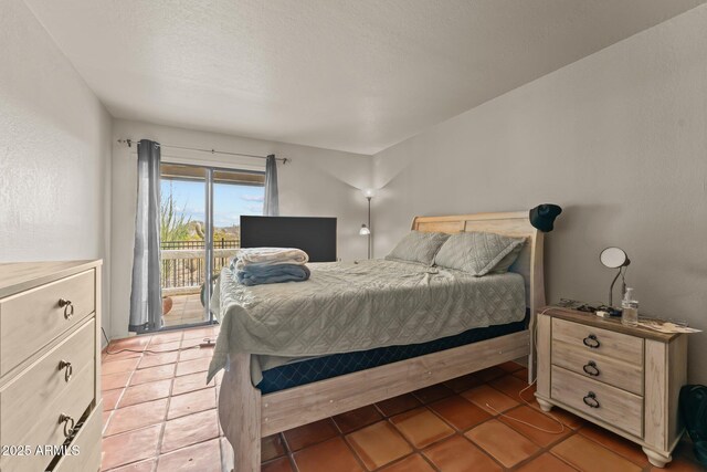 bedroom with access to outside and light tile patterned flooring